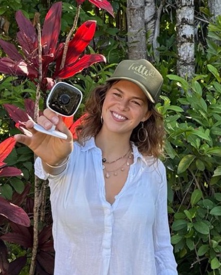 Smiling babysitter holding camera