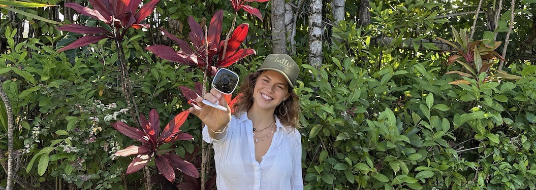 Smiling babysitter holding a child in Los Angeles tropical garden